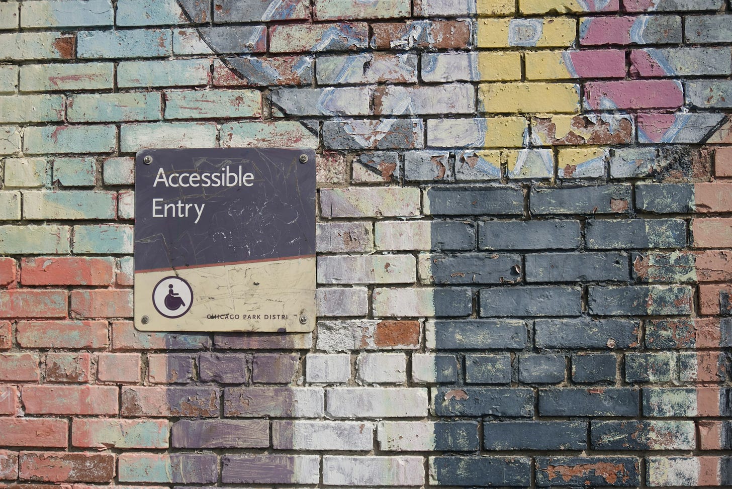 A picture of a sign that points you towards an accessible entrance. A picture of a sign that points you towards an accessible entrance.