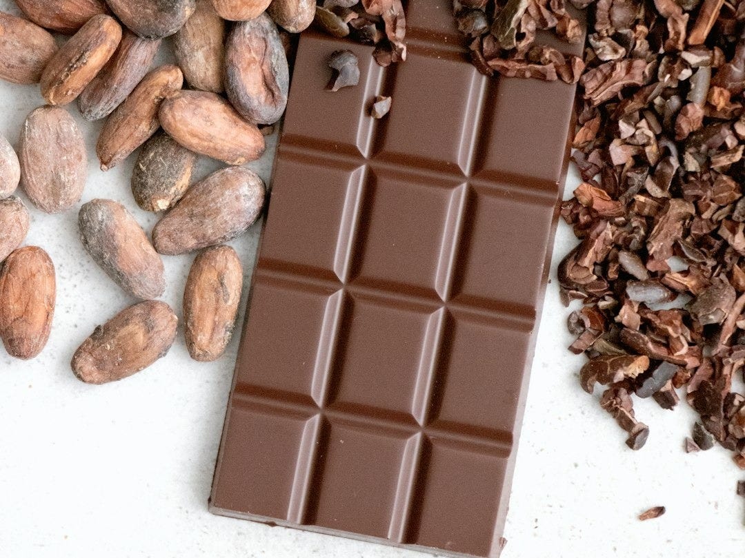 a bar of chocolate next to a pile of nuts