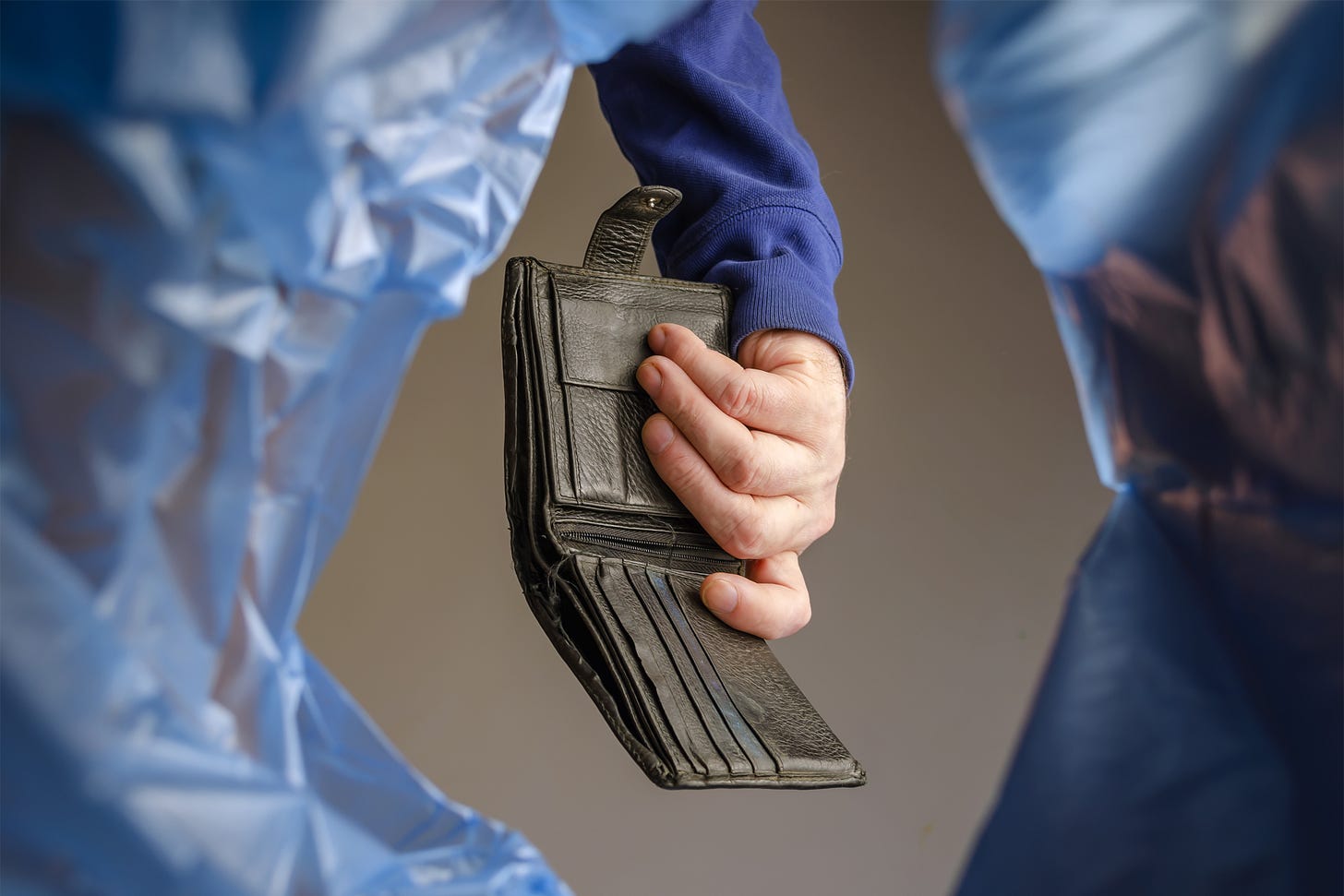 Hand tossing wallet into the garbage