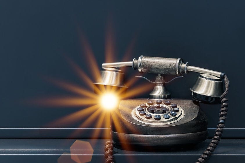 Old telephone handset glowing from the nozzle