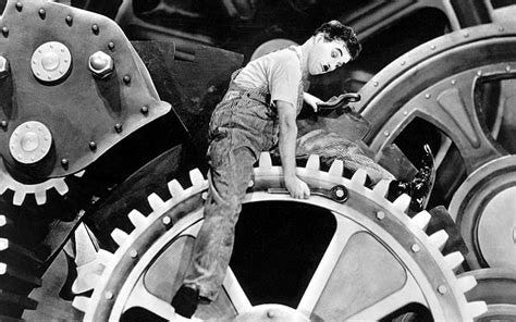 A still image from Charlie Chaplin's film "Modern Times", showing him inside a big metal machinery