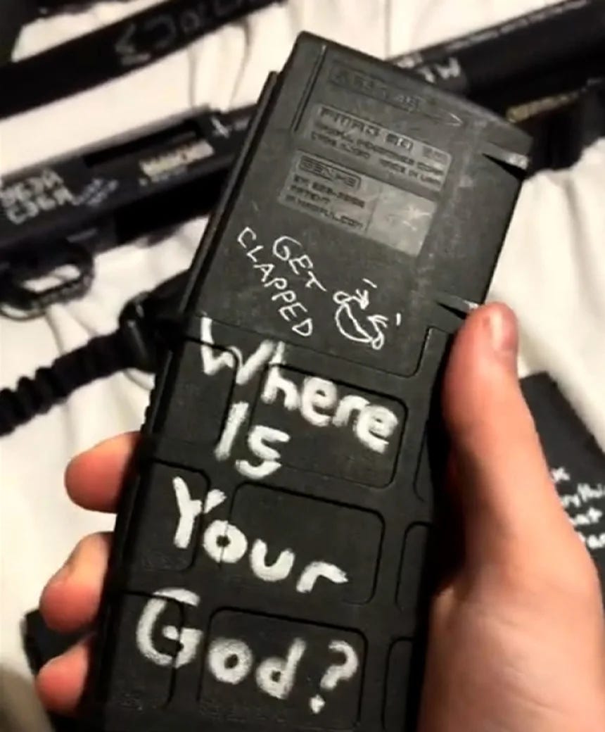 Robin Westman holding a magazine with white marker with the text "where is your god?" and "get clapped"