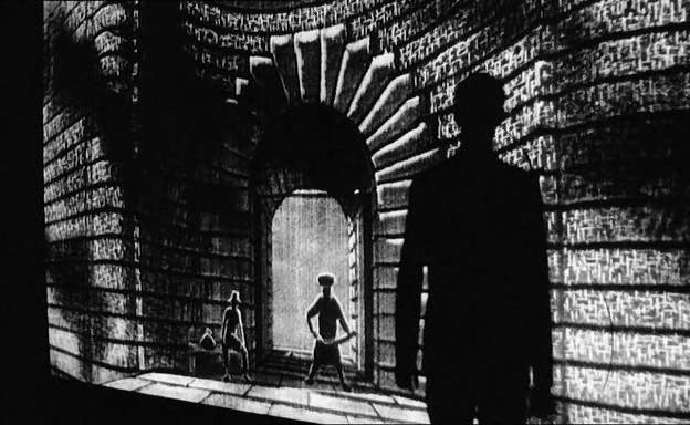 A gatekeeper stands before a door. A man approaches.