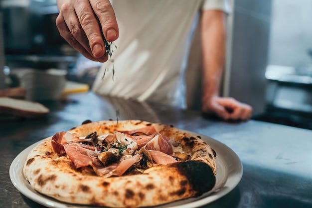 Premium Photo | An italian chef garnishes the pizza just out of the stone  oven.