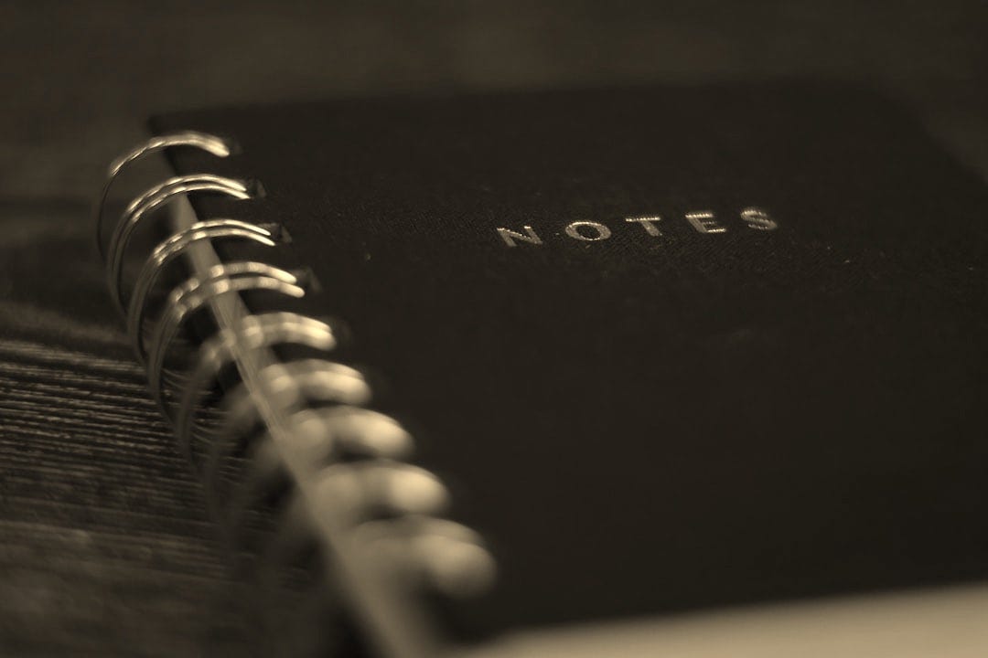 A black notebook with a gold spiral binding.