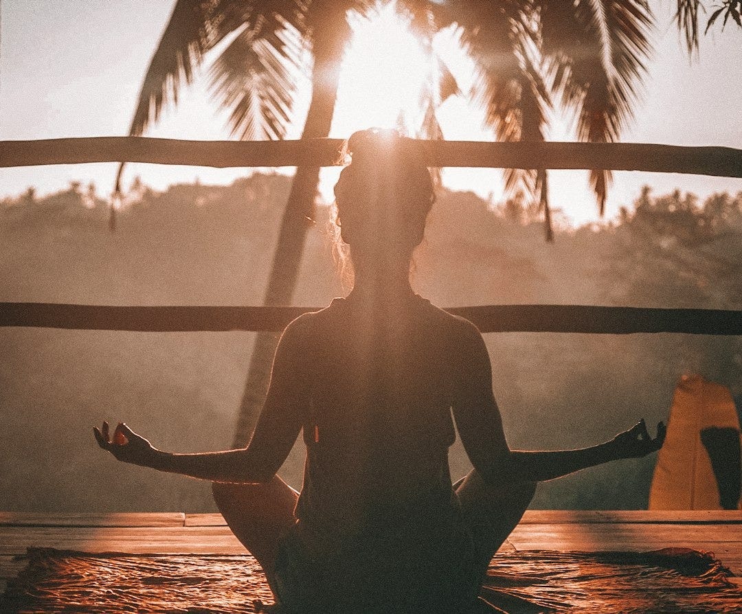 woman doing yoga meditation on brown parquet flooring