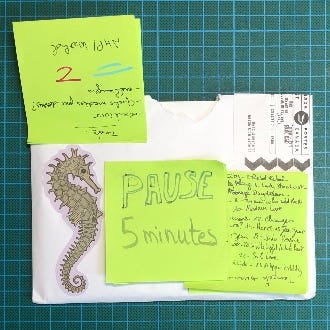On voit l'enveloppe posée sur mon tapis de découpe, avec un bel autocollant représentant un hippocampe. Plusieurs post-it vers servent à masquer son adresse et la mienne.