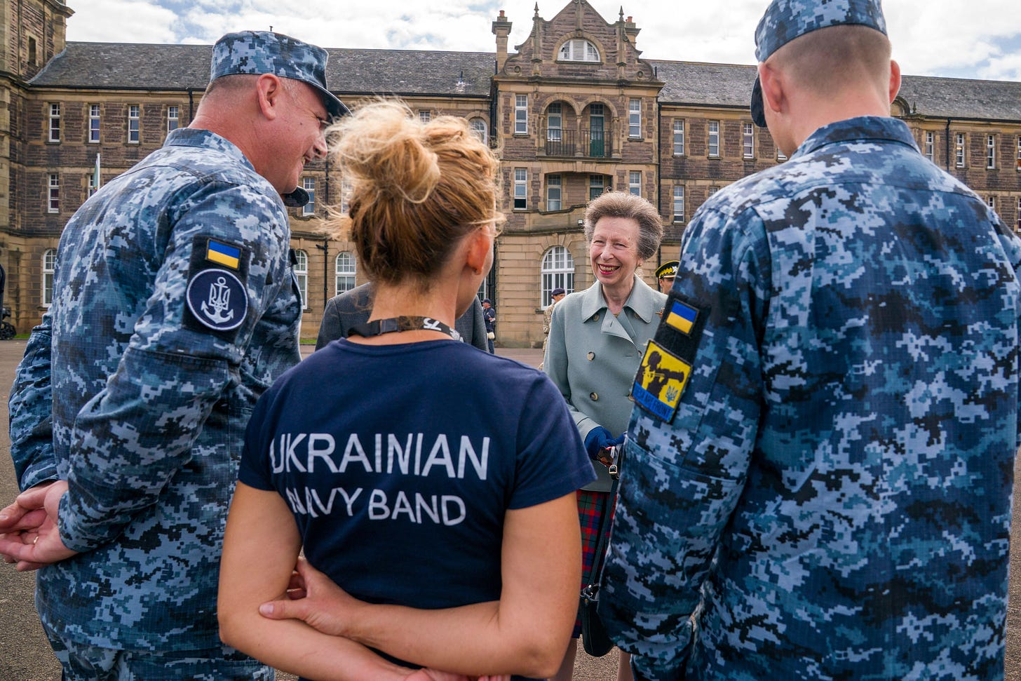 Princess Anne dressed in tartan speaking to Ukrainian military band