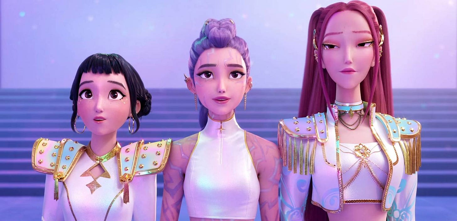 HUNTR/X from KPop Demon Hunters stand onstage, wearing white and gold
