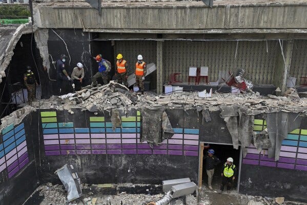 Rescue workers stand at site of the Jet Set nightclub days after its roof collapsed during a concert, killing more than 200 people in Santo Domingo, Dominican Republic, Thursday, April 10, 2025. (AP Photo/Matias Delacroix)