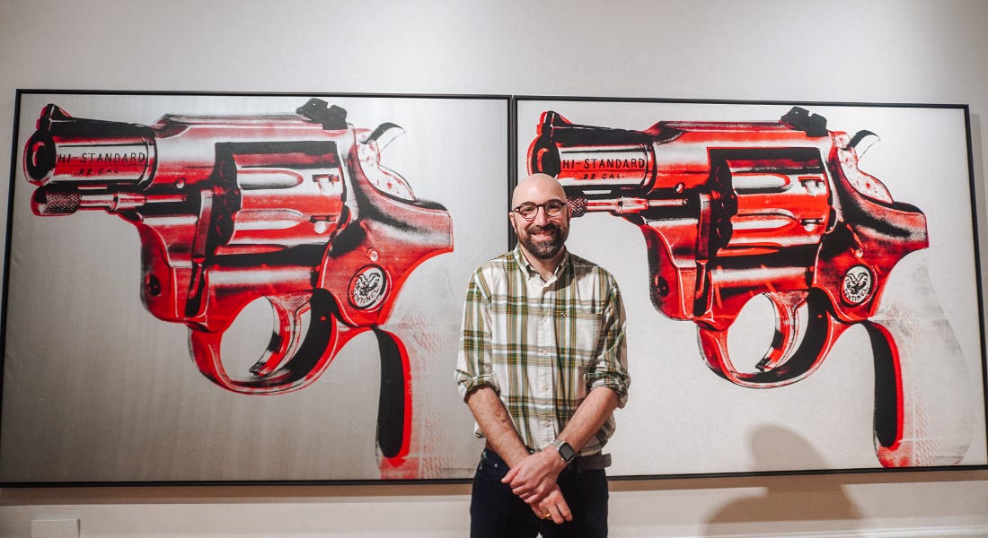 Andy Warhol's work 'Gun' with red guns, with Ashley Gallant in front of them Andy Warhol's work 'Gun' with red guns, with Ashley Gallant in front of them