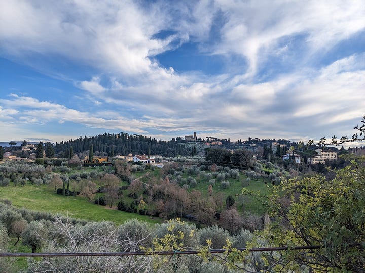 Author in Boboli Gardens. A Florentine hillside scene with a castle atop the hill.