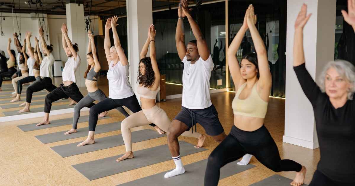People doing raised hand pose in yoga class