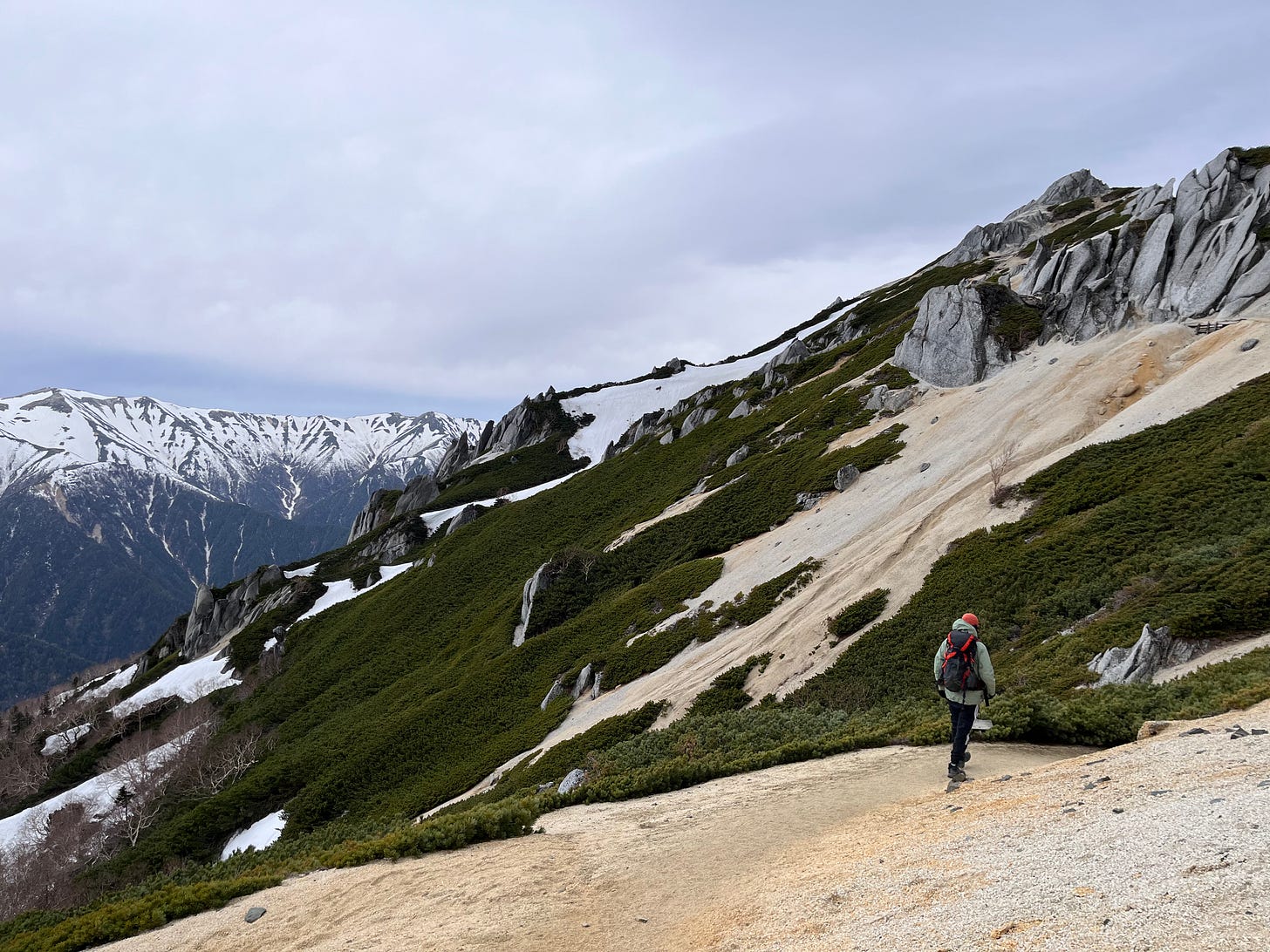 gray mountains with a figure with a backpack in the foreground
