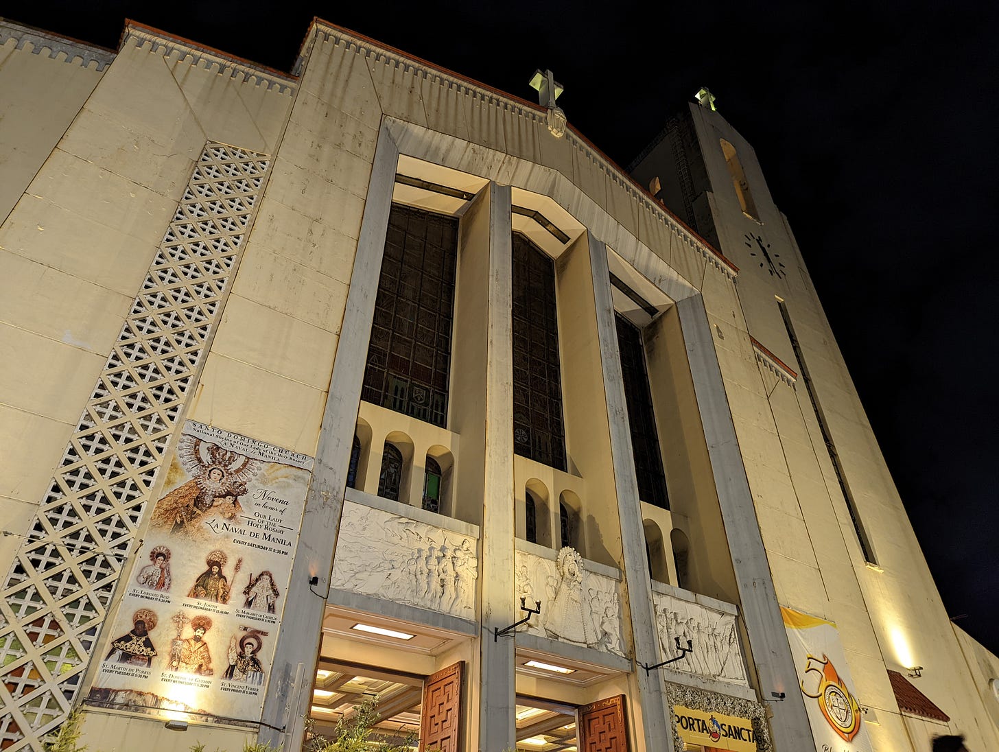 The well-lit exterior shot of Santo Domingo Church with two of three of the main doors visible