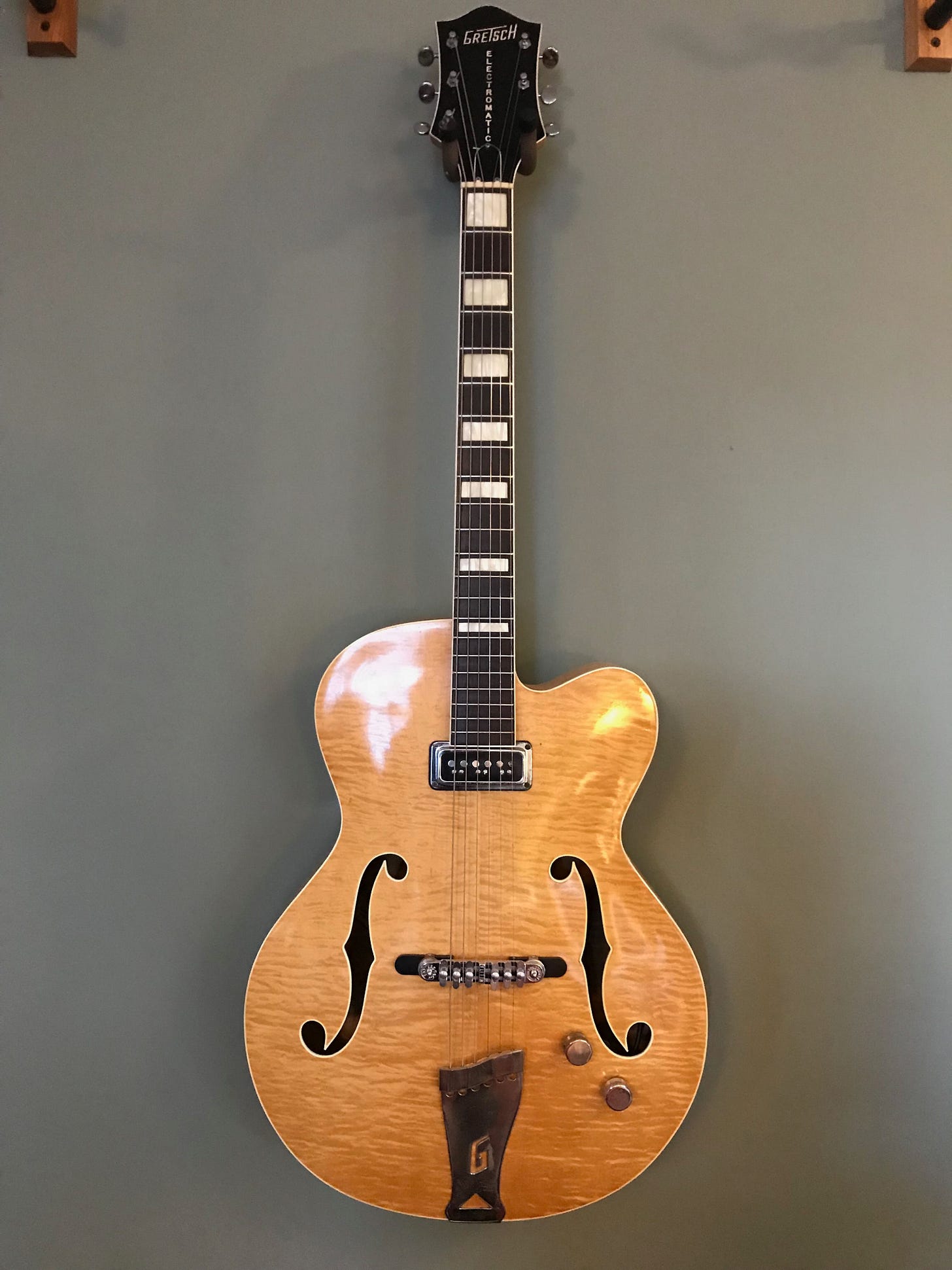 A guitar leaning against a wall

Description automatically generated with medium confidence