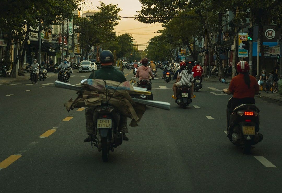a group of people riding motorcycles down a street a group of people riding motorcycles down a street