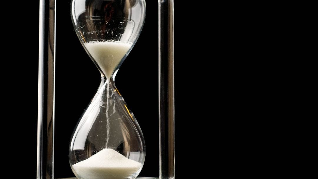 A white hourglass against a black background, representing the themes of time management, balance, and productivity.