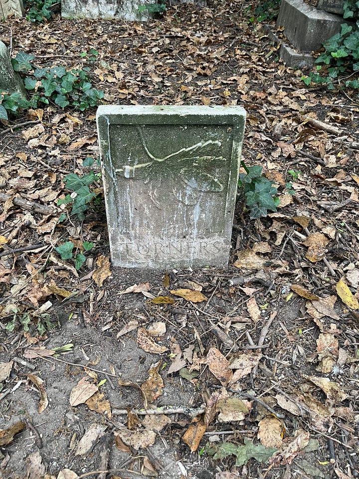 Four stone markers with inscribed illustrations and names of plants in the cemetery