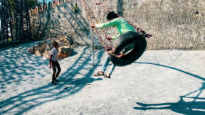Children playing on swings at Udaan Park, Udaipur, Rajasthan