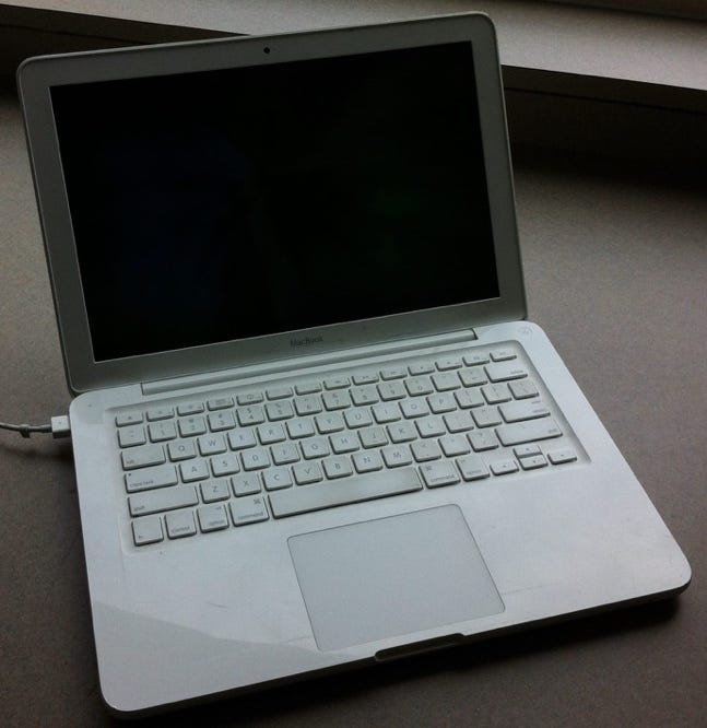 A white computer with a black screen

Description automatically generated