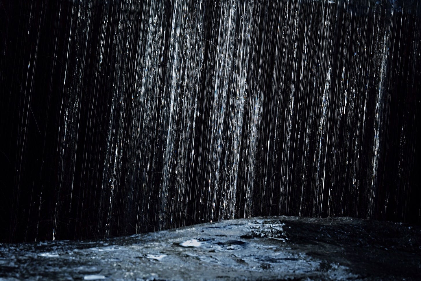 Torrential rain landing in a river on the cusp of a waterfall