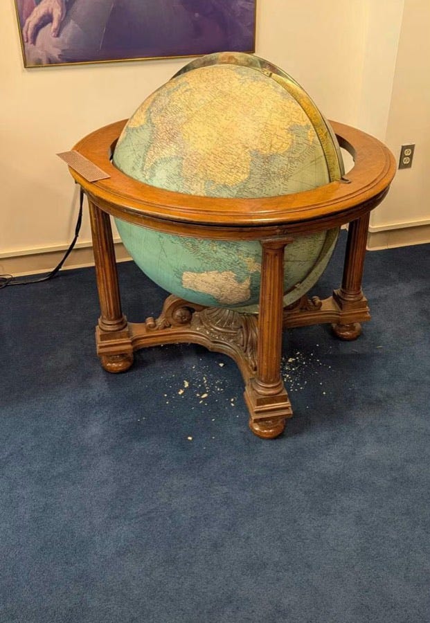 The Eisenhower globe in the Pentagon, knocked loose in its wooden stand, with chips of its shell scattered on the blue carpet The Eisenhower globe in the Pentagon, knocked loose in its wooden stand, with chips of its shell scattered on the blue carpet