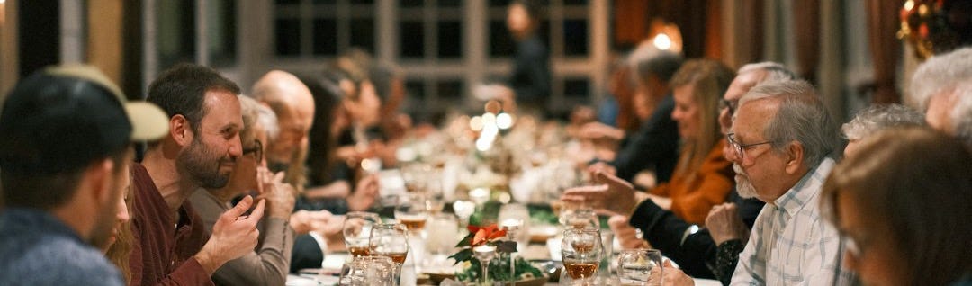 a group of people sitting at a long table