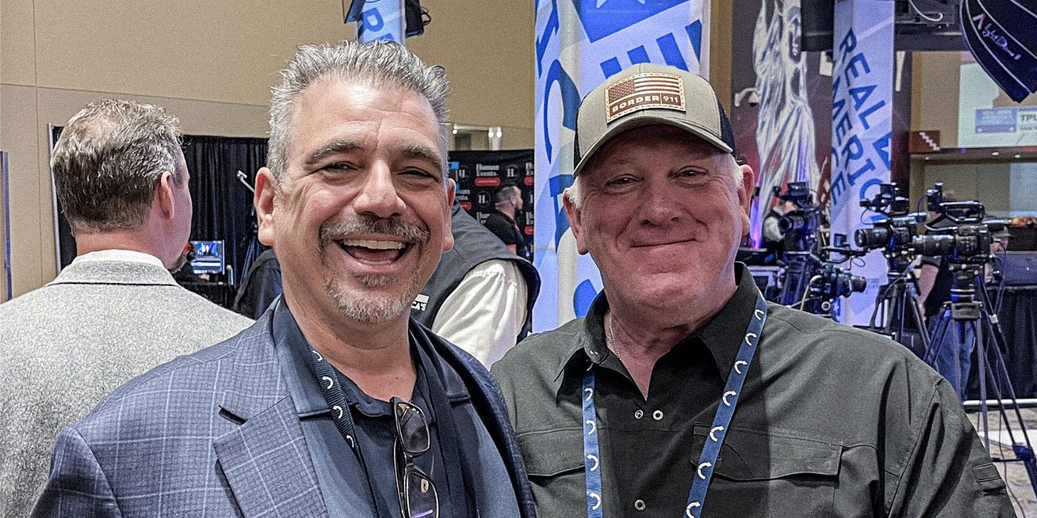 Two people pose for photo inside.