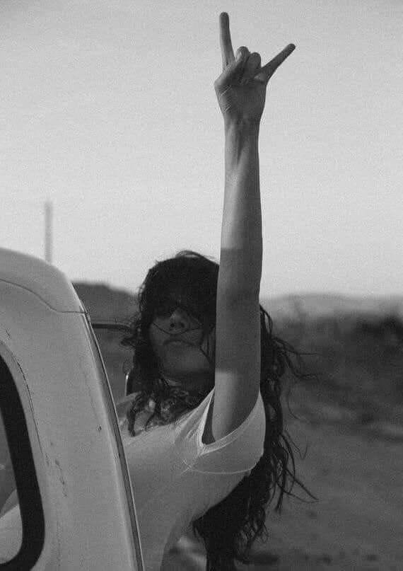 girl hanging out of a car completely unbothered and carefree