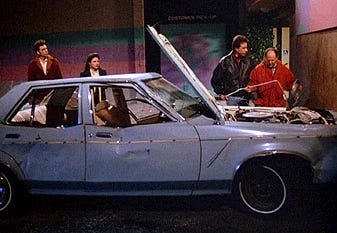Seinfeld cast standing around a battered car parked in a handicap spot. Seinfeld cast standing around a battered car parked in a handicap spot.