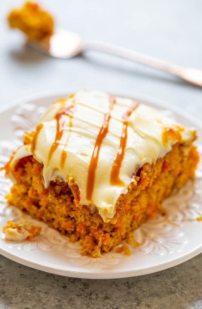 A slice of Salted Caramel Carrot Cake with Cream Cheese Frosting on a plate. 