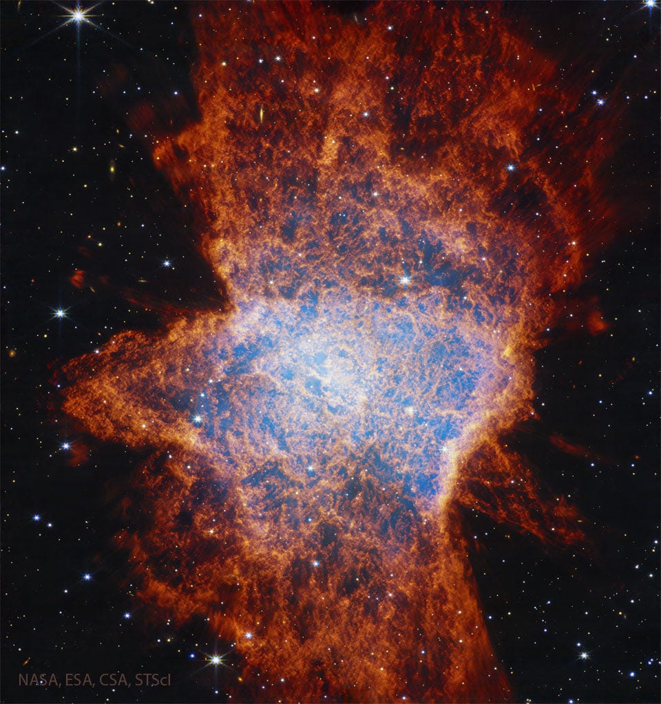A starfield is shown dominated by a complex
nebula shown with many red filaments and with a
light glow in a region near the center. 
Please see the explanation for more detailed information.