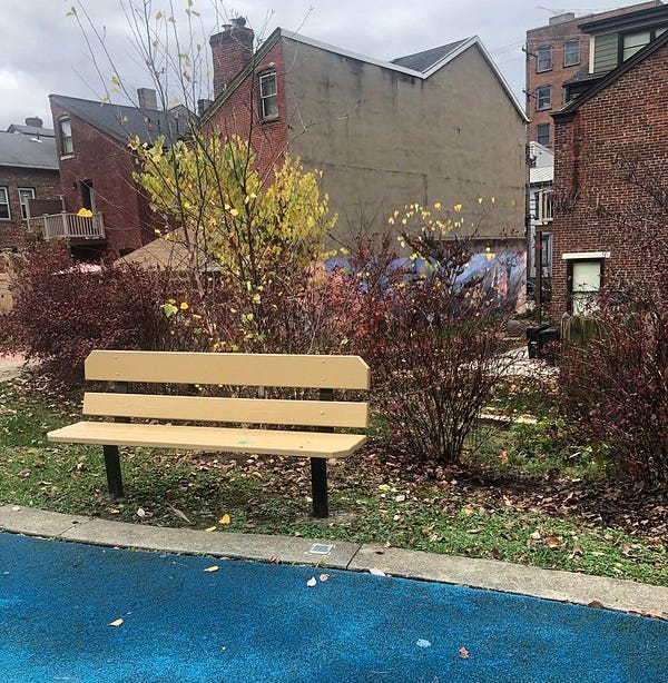 Bench and old brick row houses at Alpine Gardens Park, Central Northside