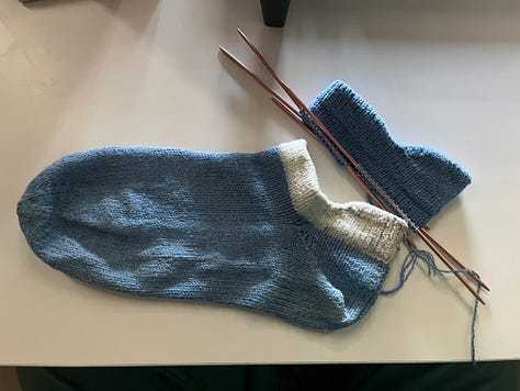Photos showing the process of knitting and attaching new cuffs to a pair of blue handknit socks