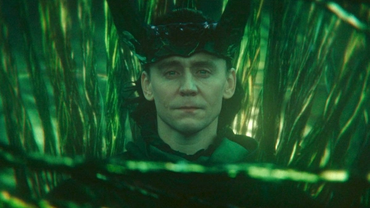 Loki sits on a throne surrounded by glowing green strands representing branching timelines in the Loki Season 2 finale.