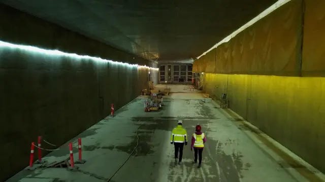 Two people walking through one of the tubes Two people walking through one of the tubes