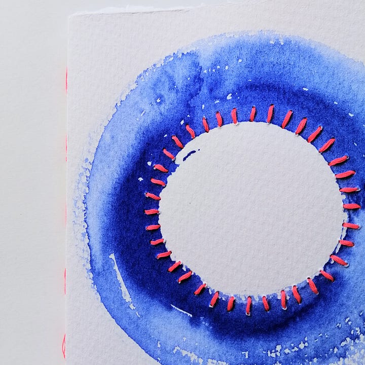 Four watercolour painted handmade notebooks with stitched details.