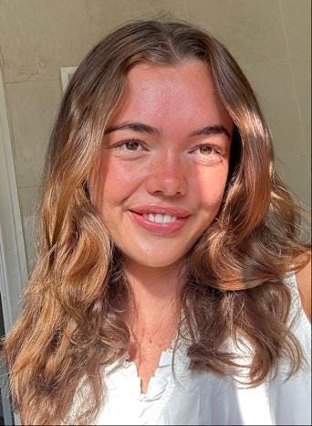 A person smiling at the camera

Description automatically generated