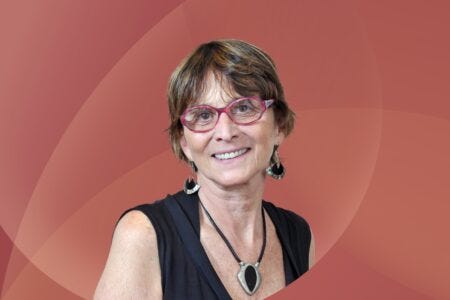 Headshot of Helena Nader, President of the Brazilian Academy of Sciences. She is wearing red glasses with a black sleeveless shirt.