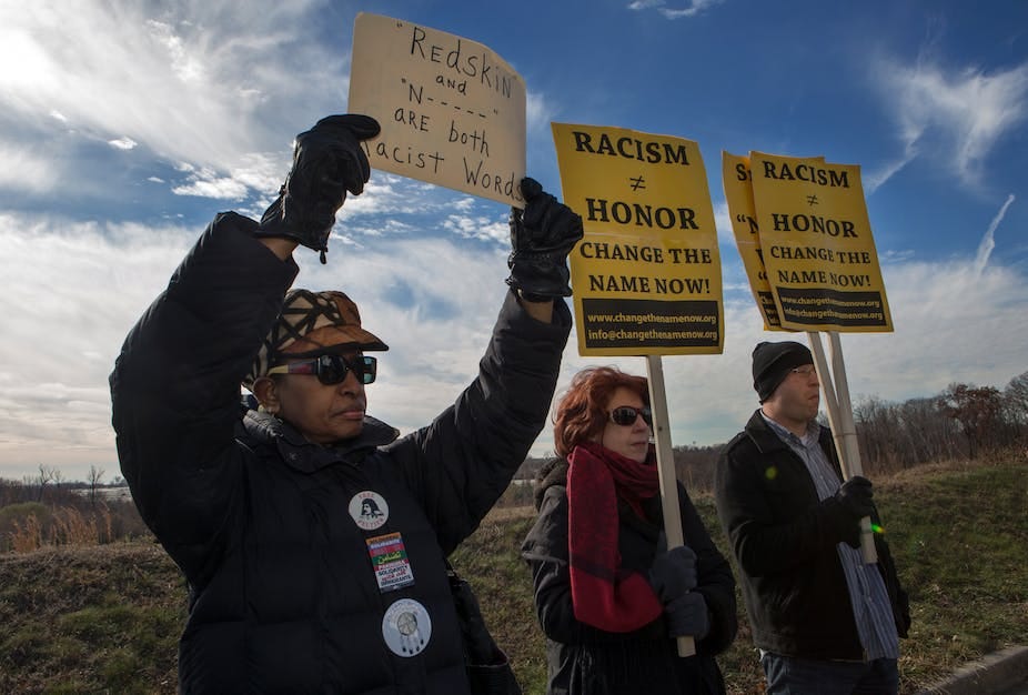 Two women and a man carrying placards in protest Two women and a man carrying placards in protest