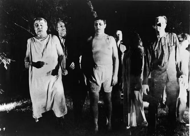 Scene from black and white film showing group of zombie-like characters