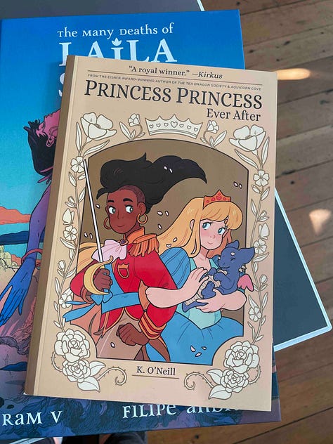 5 images with books being held by a hand and a tabletop covered in Graphic Novels. Titles include: Belly Full of Heart; In Limbo; Special Topics in Being a Parent; Viewfinder; Princess Princess