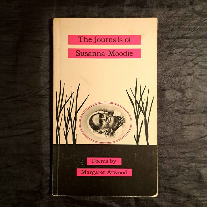 photo of an old hardcover book, The Stone Angel, and an old paper back of Laurence's The Diviners on a wooden table, and an image of Margaret Atwood's Susanna Moodie poetry book on black fabric