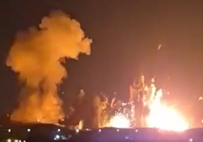 Explosion with a large plume of smoke and fire in a night sky. Explosion with a large plume of smoke and fire in a night sky.