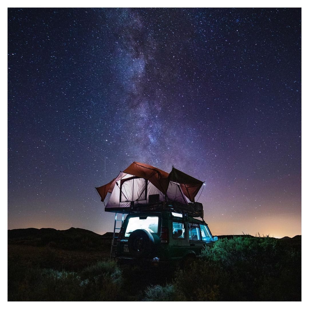 SUV with Rooftop tent at night under the stars
