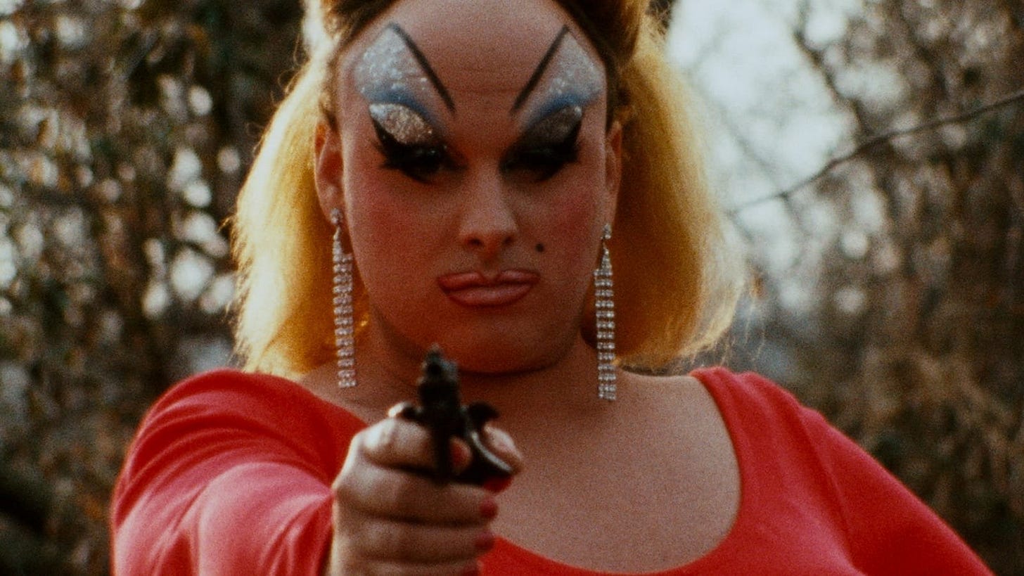 Pink Flamingos | Still features Divine pointing a gun at the camera.