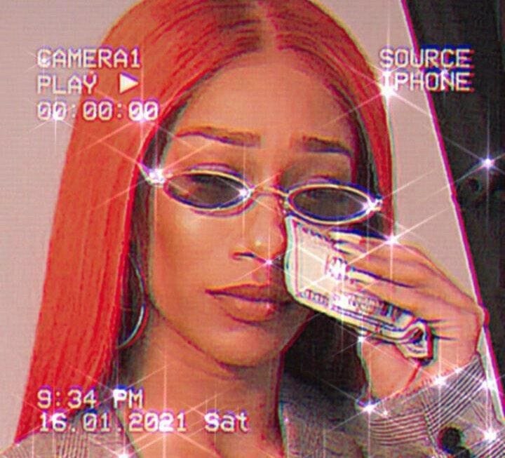 This may contain: a woman wearing glasses holding a camera in front of her face and looking at the screen This may contain: a woman wearing glasses holding a camera in front of her face and looking at the screen