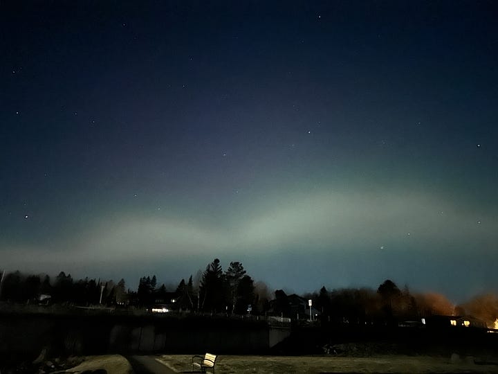 Photos of the pine trees again the Northern Lights, a bright moon over Lake Superior and stars in the sky.