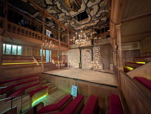 A stage with red seats and chandeliers

AI-generated content may be incorrect.